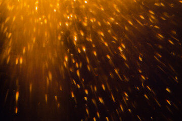 Blurred bokeh light sparkle on golden black background