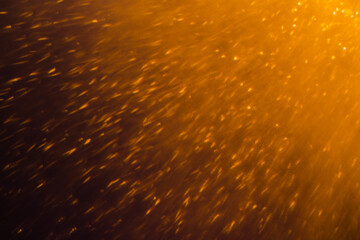 Blurred bokeh light sparkle on golden black background