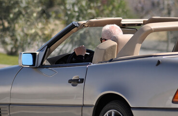 Man driving a cabriolet car on a hot sunny day, driving pleasure and fun