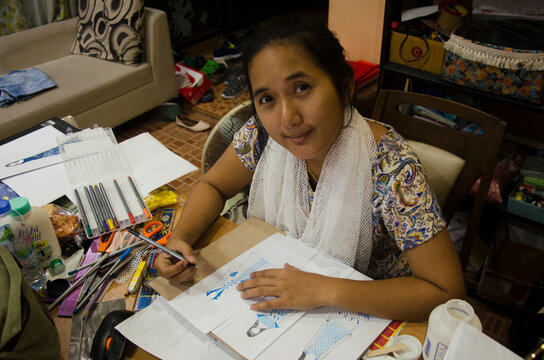 Thai designer women drawing and design pattern fashion on paper for make mood board and cut clothes