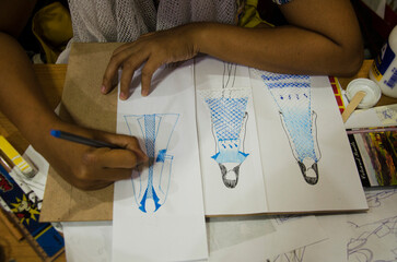 Thai designer women drawing and design pattern fashion on paper for make mood board and cut clothes