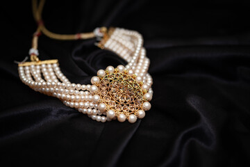 Close up of a diamond necklace with pearls on black background.