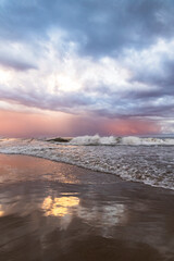 Moody Sunset Over the Beach of Tamarit, Spain, with Ocean Waves and Dramatic Sky