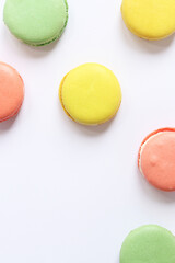 Sweet colorful macarons on white background. Delicious pastries, flat lay. Food background. Sweets. Bright French macarons on white background, top view. Assortment of colorful macarons