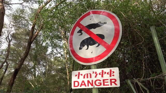 Beware of crocodiles and hippos sign before entry to Lake Chamo in Nechisar national park in Ethiopia, wildlife in Africa
