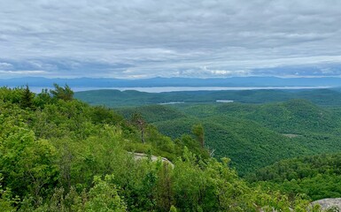 Obraz premium Scenic view of lush green hills and a distant lake.