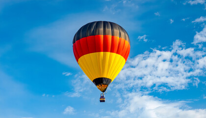 Naklejka premium Colorful hot air balloon soaring against a clear blue sky during a sunny day in Germany