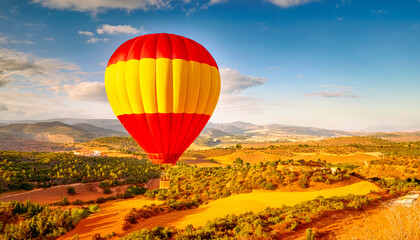 Hot air balloon floating above picturesque landscape during sunset in a serene countryside