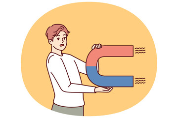 Worried man with magnet looks scared at screen for concept of trying to attract customers to company. Confused guy with magnet symbolizing unsuccessful marketing strategy for advertising business