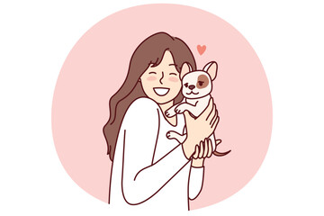 Little girl hugs puppy given for birthday and rejoices at dog become best friend for child. Happy female teenager with miniature dog enjoys interacting with cute pet adopted from shelter