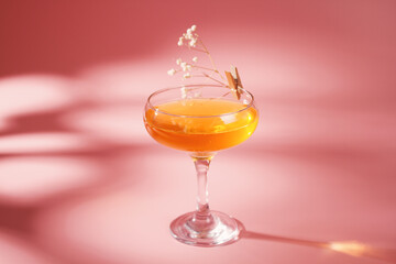Glass with cocktail on pink background. Alcoholic cocktail