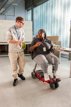 Disabled man and woman talking in workshop