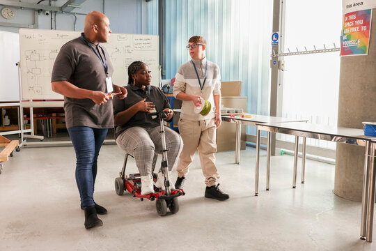 Disabled men and woman talking in workshop