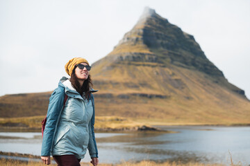 Naklejka premium Tourist walking near kirkjufell mountain in iceland during fall season