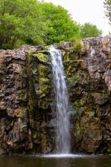 Obraz premium A rocky waterfall in the dry season with trees on the background
