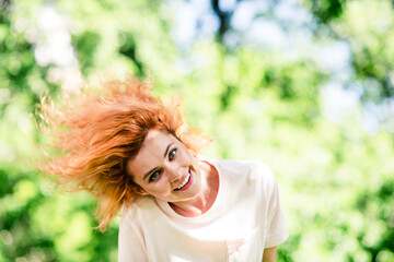 Fototapeta premium Photo of nice young woman enjoy free time flying hair wear t-shirt walk fresh air park outdoors