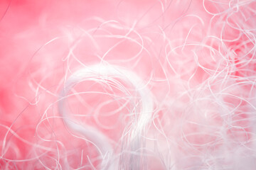 Extreme macro of polyester stable fiber on red background. Selective focus, shallow depth of field. Abstract dreamy background