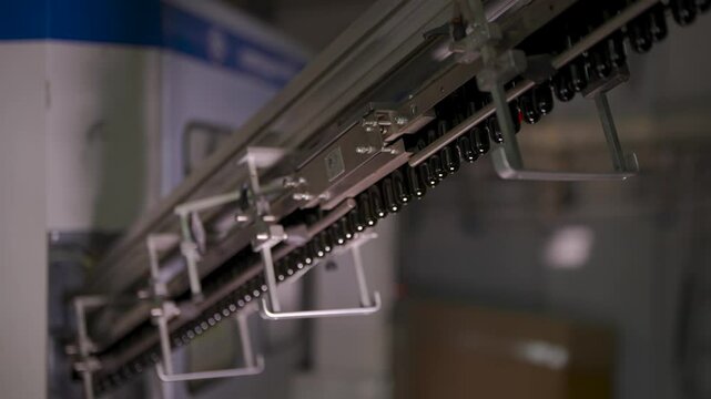 Preform bottles move along an automated conveyor system in a beverage production facility. These small plastic preforms will later be heated and expanded into full-sized bottles. The high-tech industr