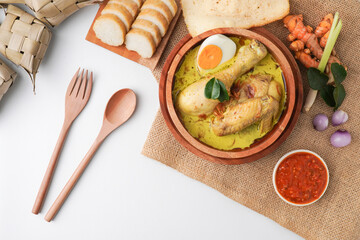 Lontong opor ayam is an Indonesian traditional dish usually served during eid Mubarak, Eid al Fitr holiday celebration with Ketupat Lebaran or rice cake dumpling and sambal chili sauce.