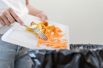 Compost from leftover food in the meal in household, female hand holding left over meal use fork...