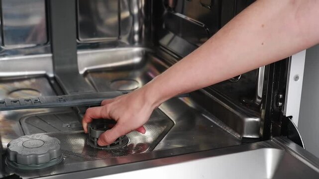Housekeeper removes, cleans and replaces a dishwasher filter