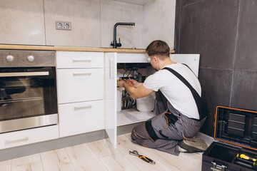 Plumber Installing Water Filter System Under Kitchen Sink