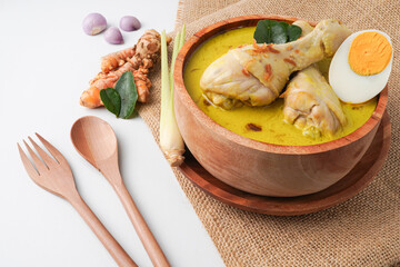 Lontong opor ayam is an Indonesian traditional dish usually served during eid Mubarak, Eid al Fitr holiday celebration with Ketupat Lebaran or rice cake dumpling and sambal chili sauce.