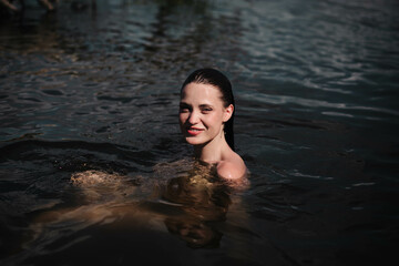young woman swims in the pond and enjoys, rest in the lake river.