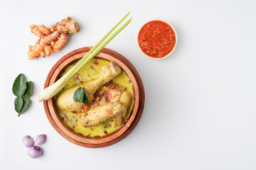 Lontong opor ayam is an Indonesian traditional dish usually served during eid Mubarak, Eid al Fitr holiday celebration with Ketupat Lebaran or rice cake dumpling and sambal chili sauce.