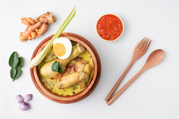 Lontong opor ayam is an Indonesian traditional dish usually served during eid Mubarak, Eid al Fitr holiday celebration with Ketupat Lebaran or rice cake dumpling and sambal chili sauce.