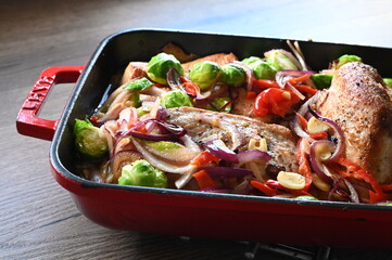 A wholesome and flavorful dish featuring oven-roasted turkey breast, crispy bacon, Brussels sprouts, red onions, and red bell peppers.