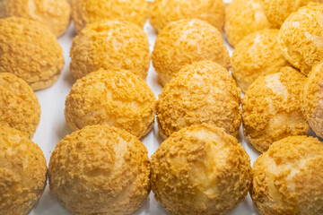 A beautifully designed restaurant communal space features sleek wooden benches positioned near a floor-to-ceiling glass facade, allowing natural light to flood the area. The warm tones of the wood