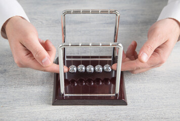 Male hand showing cradle balls. Business
