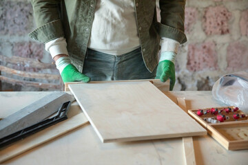 Caucasian craftsman with a wooden plank in workshop.