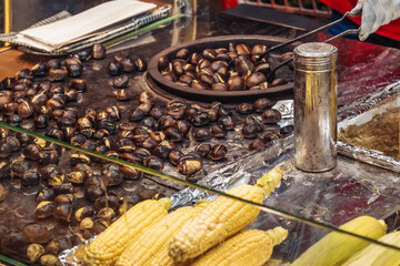 Roasted chestnuts at a bustling oriental bazaar in the evening.