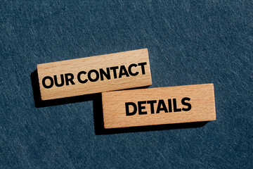 Our contact details message written on wooden blocks on gray background. Conceptual our contact details symbol. Copy space.