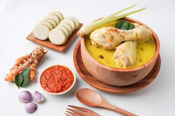 Lontong opor ayam is an Indonesian traditional dish usually served during eid Mubarak, Eid al Fitr holiday celebration with Ketupat Lebaran or rice cake dumpling and sambal chili sauce.