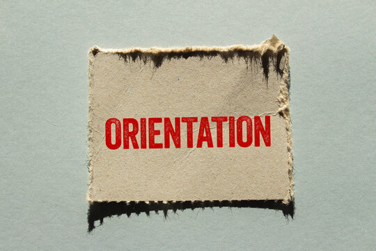 Orientation message written on ripped torn paper piece on gray background. Conceptual orientation symbol. Copy space.