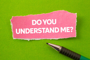 Do you understand me message written on ripped torn pink paper piece on green background....