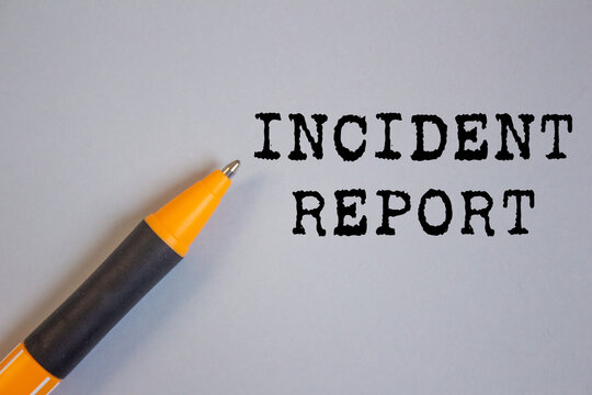 Incident report message written on gray background with a pen. Conceptual incident report symbol. Copy space.