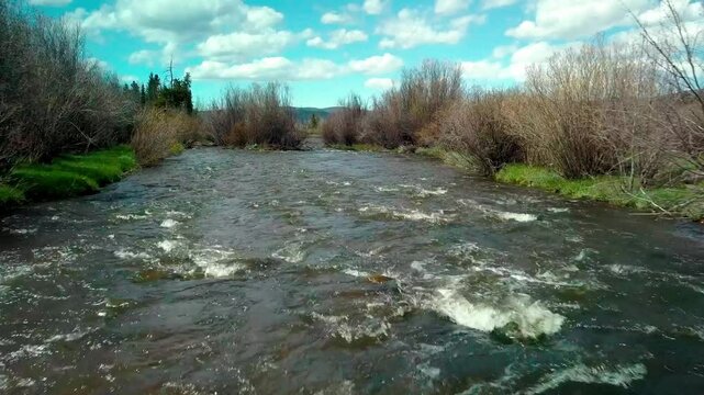 Ascending drone footage of the Fraser River flowing in Fraser town in Grand County, Colorado, USA