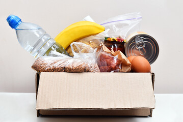 Box for donations and humanitarian aid collection, food kits in a cardboard box.