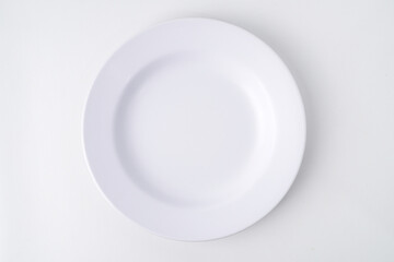 Empty white colored round shaped plate. Isolated on white background. Flat Lay Setup