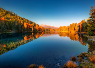 A serene landscape of a mountain lake surrounded by pine forests, with clear blue skies, soft reflections, and autumn colors.