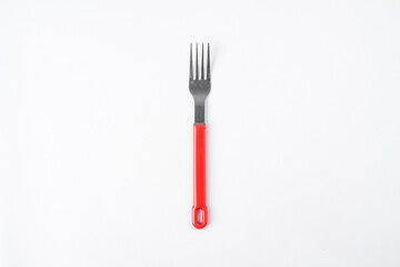 Empty white colored round shaped plate, red handle spoon and fork. Isolated on white background. Flat Lay Setup