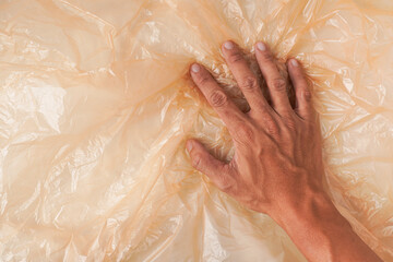 Someone hand is crumpling and wrinkling plastic sheets. Concept for zero waste and micro plastic pollution.