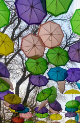 Naklejka premium Colorful umbrellas decorate the street, view from below, background concept