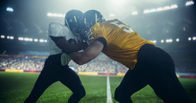 Gridiron Football Line of Scrimmage Standoff Between Two Diverse Teams Under Stadium Lights. Intense Moment of the Start of the Professional American Football Game, Players in Action During Match - Powered by Adobe