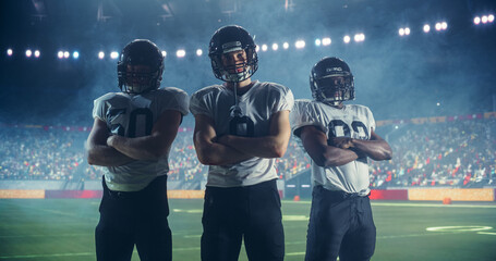 Dramatic Portrait of Three Diverse Athletic Football Players Standing Confidently on the Field, Posing Crossed Arms and Looking at Camera. Professional Footballers Before Championship Game