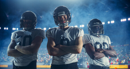 Dramatic Portrait of Three Diverse Athletic Football Players Standing Confidently on the Field, Posing Crossed Arms and Looking at Camera. Professional Footballers Before a Championship Game